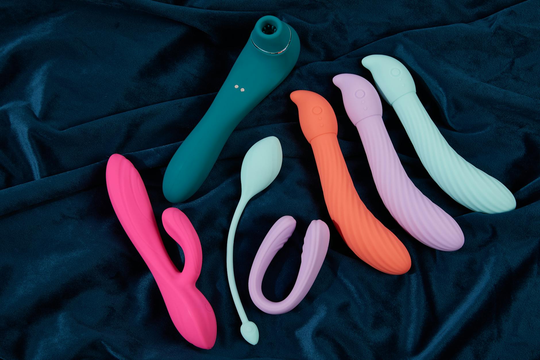 Woman wearing eyeglasses confidently holding silicone vibrators